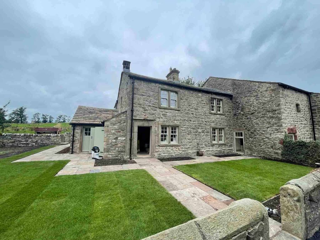 Geothermal energy system installed at a historic stone house, showcasing eco-friendly heating soluti.