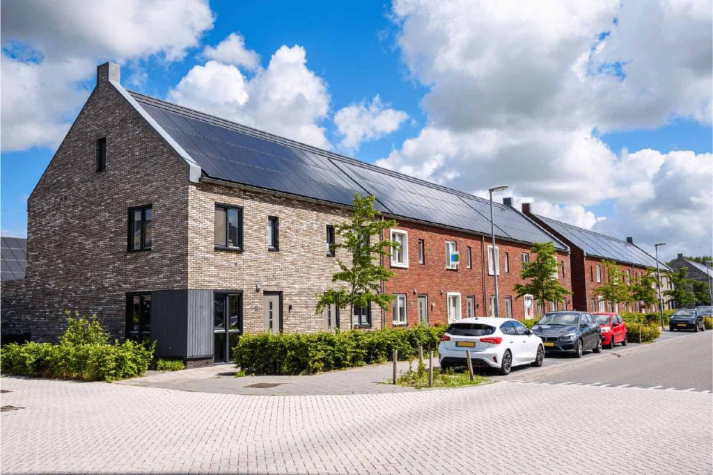 Row of modern houses with solar panels on roofs and energy-efficient design.