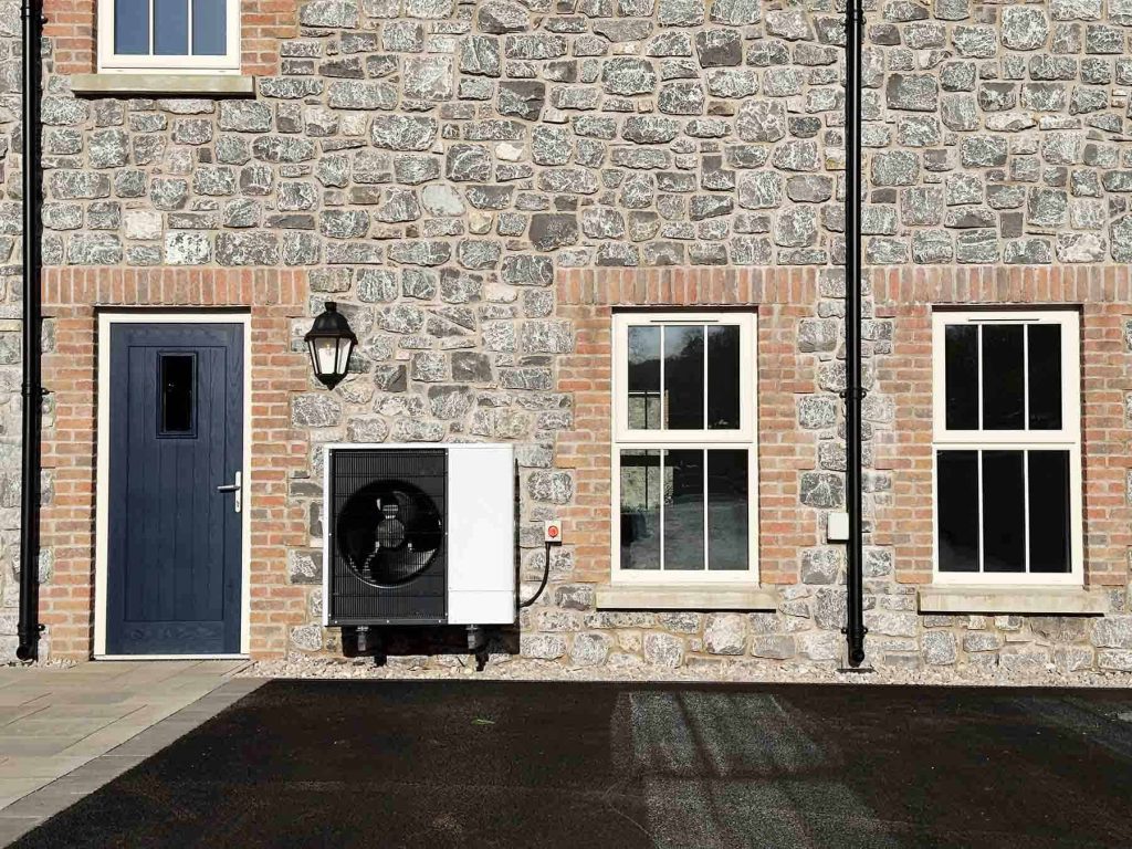 Image shows a heat pump outside a residential property