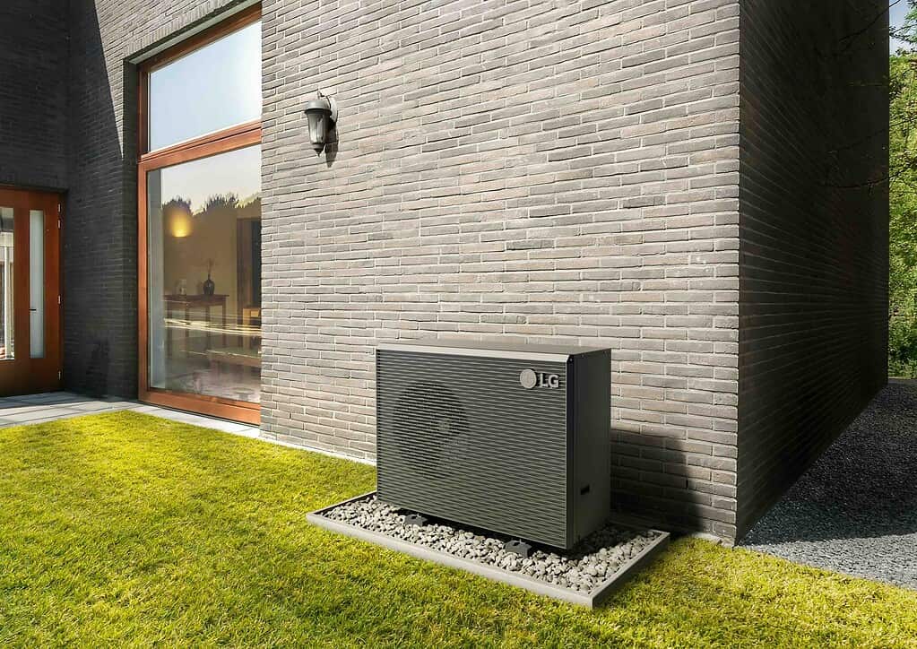 Outdoor heat pump unit installed outside a contemporary house.