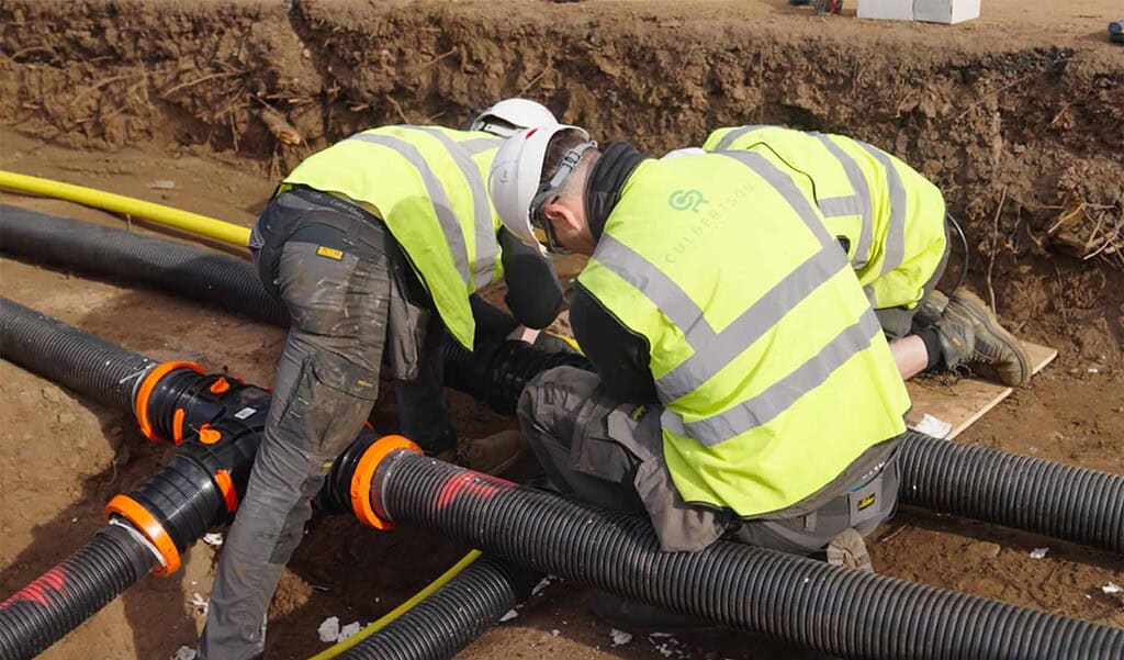 Workers installing underground piping for heat pump systems.