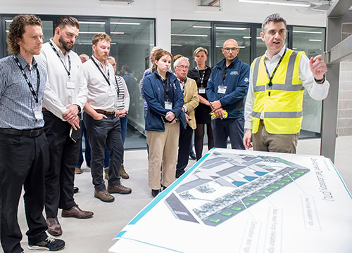 Modern engineer explaining heat pump technology to a group of professionals during a training sessio.