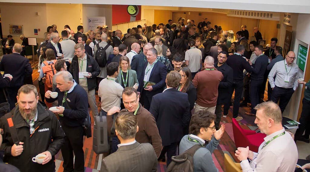 Attendees networking at the HPA UK annual conference in a busy hall.