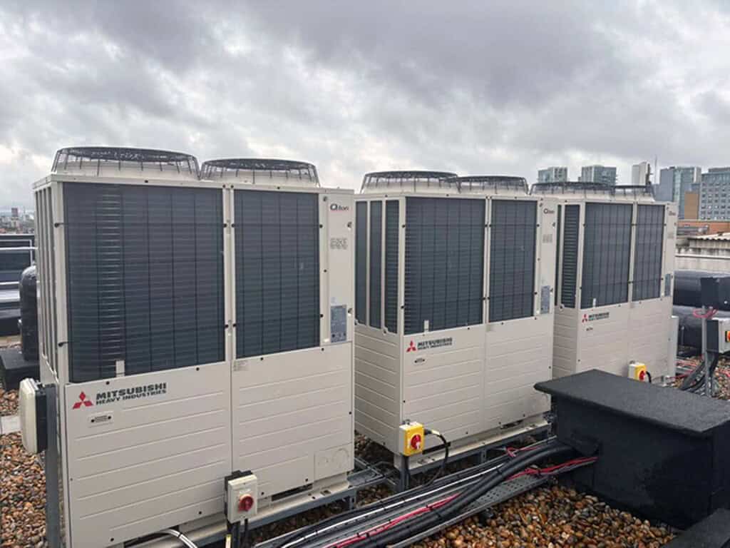 Mitsubishi heat pump units installed on a rooftop for hotel hot water system.
