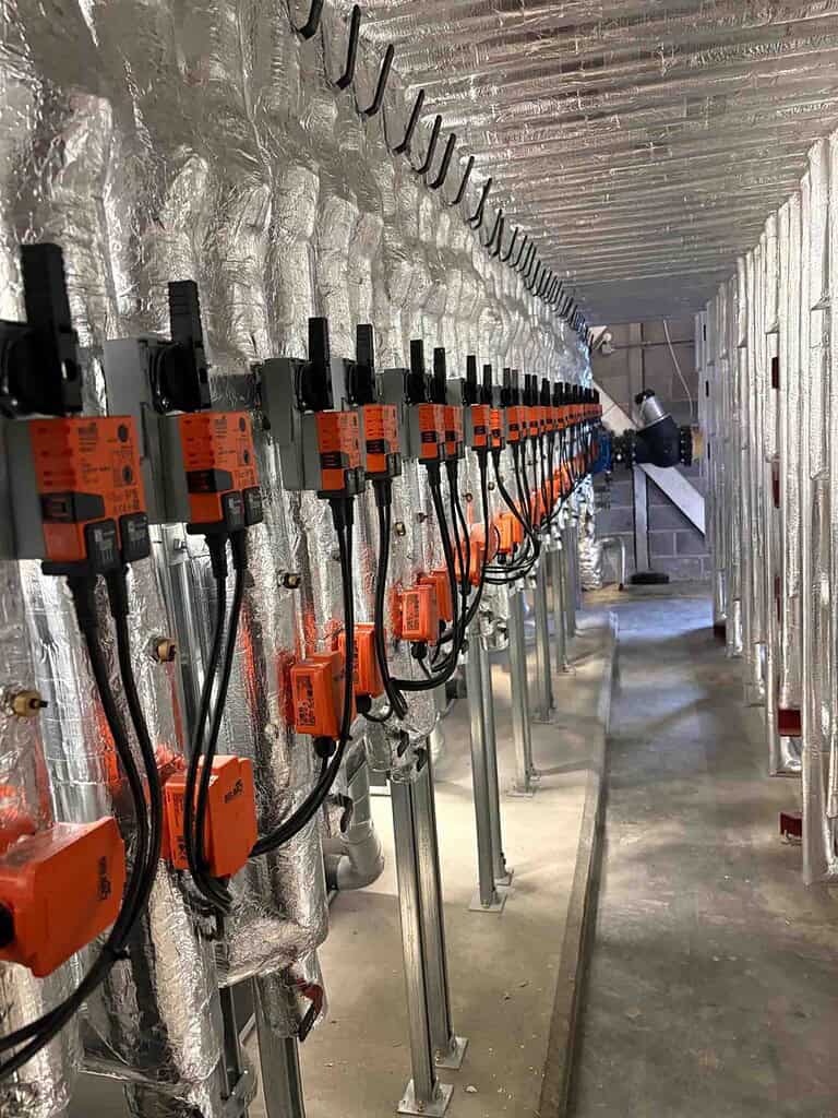 Close-up of heat pump control units installed in building insulation.