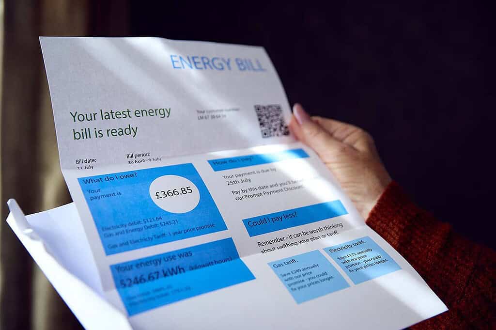 Person holding an energy bill showing a total of £366.85.