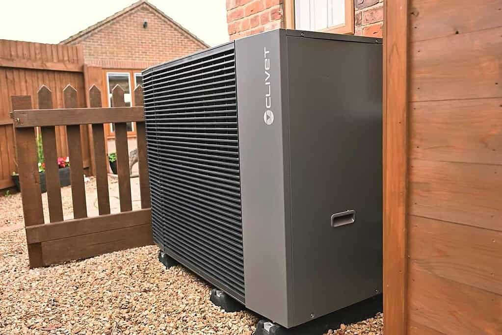 Modern heat pump outdoor unit installed in a residential garden.