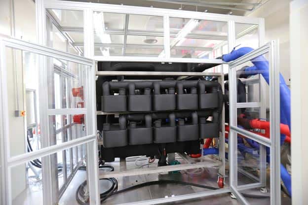 Advanced heat pump with black modules and red/blue piping for waste heat recovery.