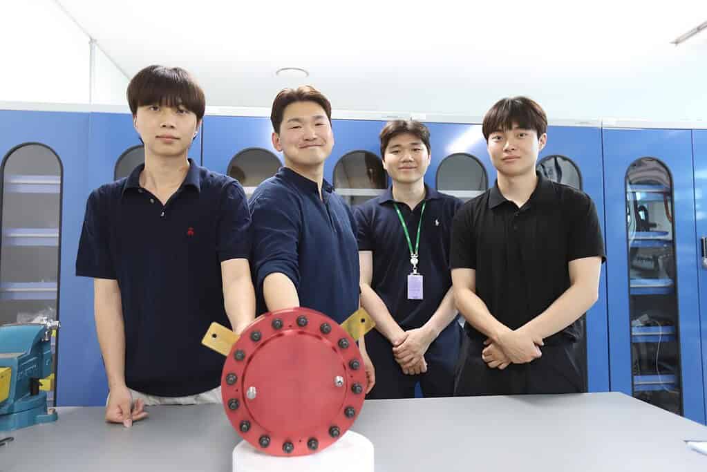 Team of engineers with heat pump prototype in lab environment.