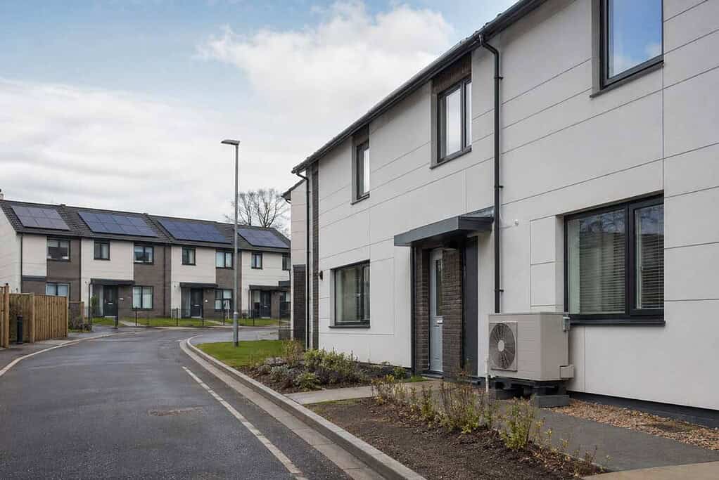 Contemporary homes with air-source heat pumps installed outside.