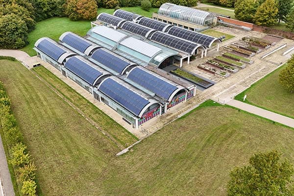 Greenhouses with solar panels at Kew Gardens for sustainable heating.