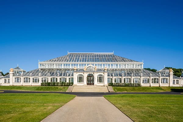 Kew Gardens glasshouse with clear blue sky in the background.