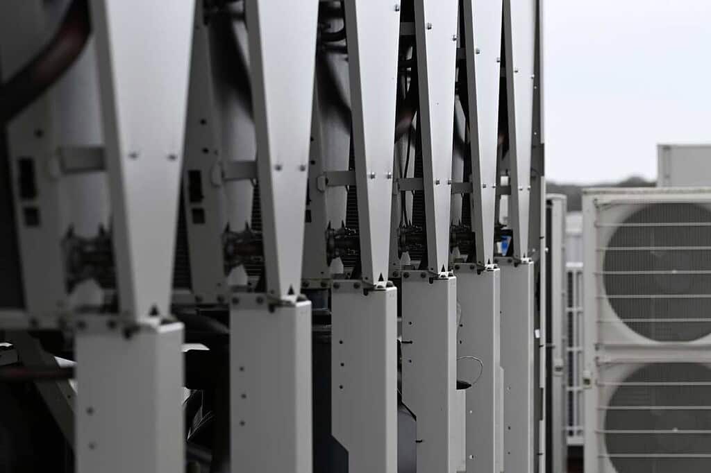 Close-up of industrial heat pump cooling units with metal framework.