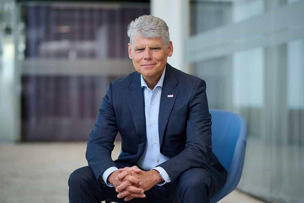 Professional businessman in suit sitting in modern office setting.