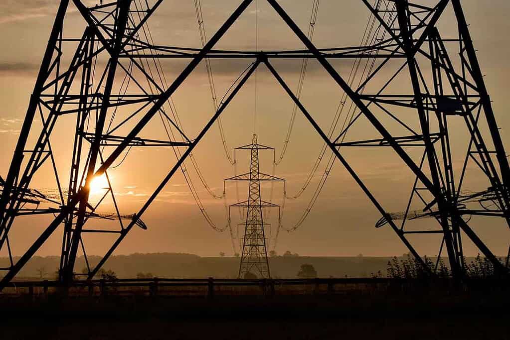 Electric power transmission towers at sunset, part of the Great British Grid.