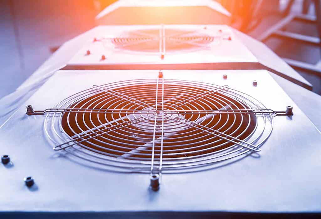 Industrial heat pump component with fan and cooling elements for HVAC systems.