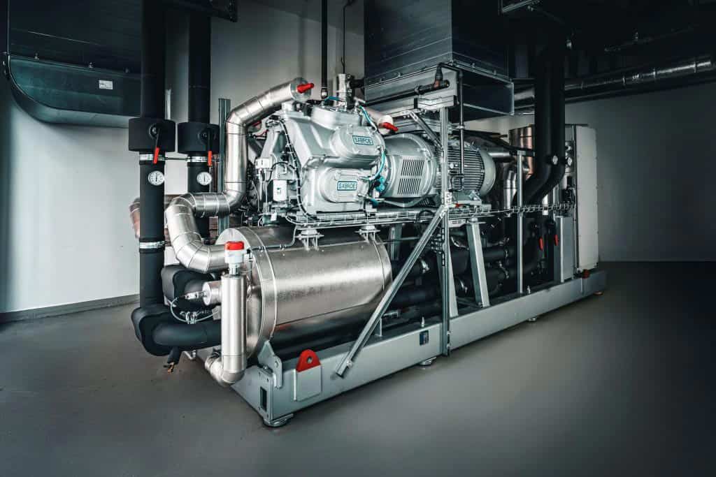 Large industrial heat pump with pipes and machinery in a modern facility.