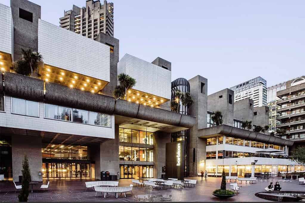 Modern Barbican Centre in London with illuminated exterior at dusk.