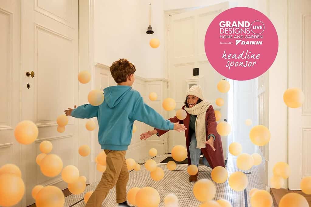 Child and woman enjoying playful moment with floating balls in a bright room.