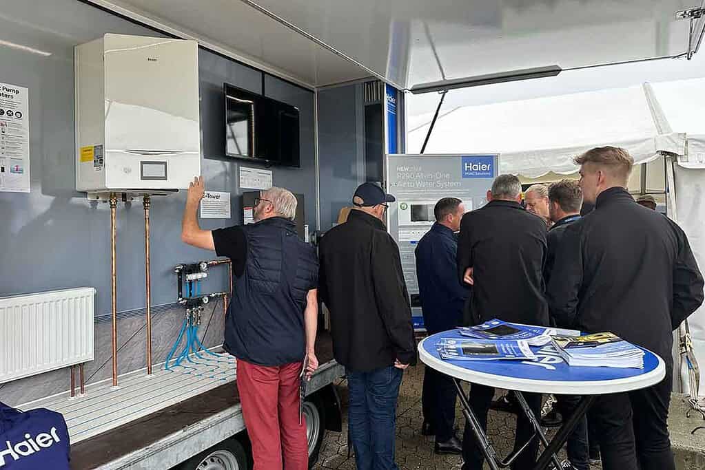 People viewing Haier R290 air-to-water heat pump at a trade event.
