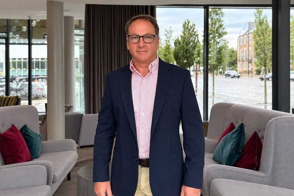 Mark Burton in a modern office setting with sofas and large windows.