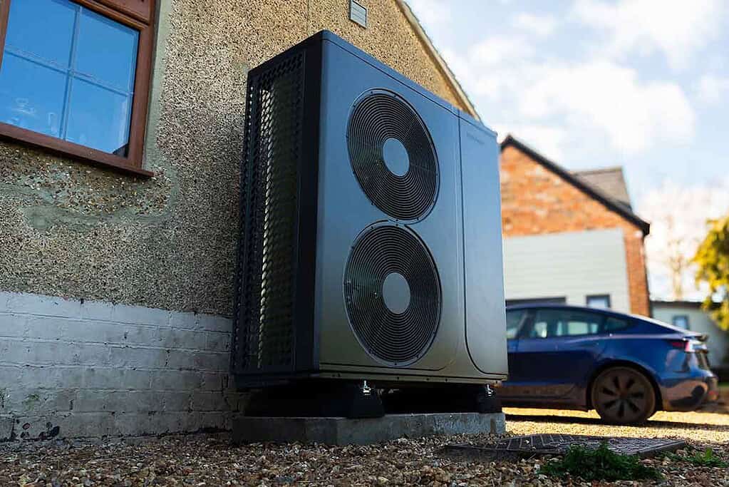 Modern heat pump outdoor unit installed outside a building for efficient heating.