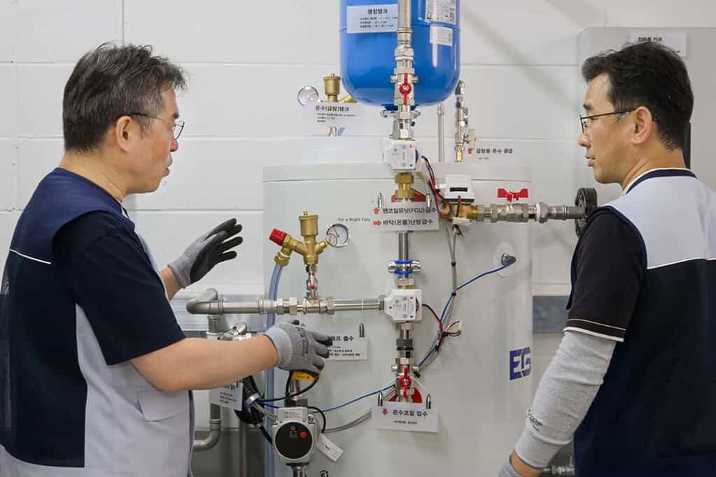 Technicians inspecting heat pump equipment at training centre in Suwon, South Korea.