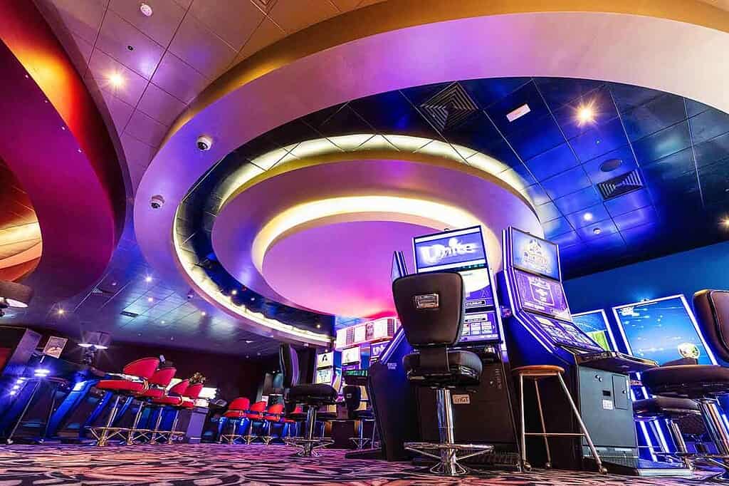 Modern casino interior with gaming machines and vibrant lighting.