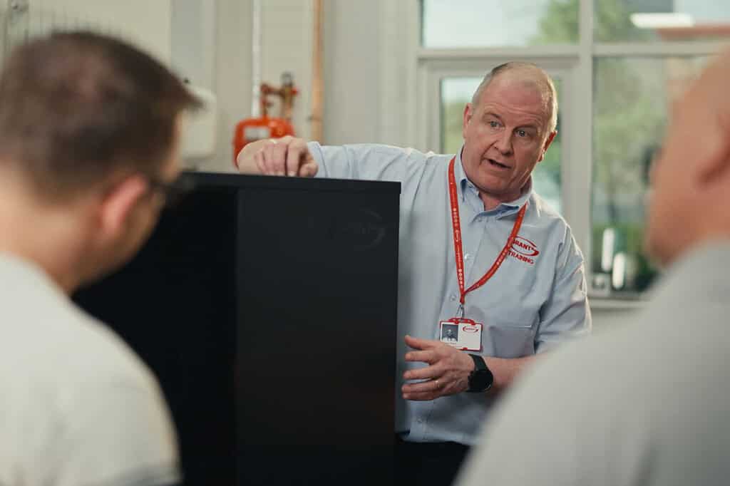 Instructor explaining heat pump technology to students in a classroom.