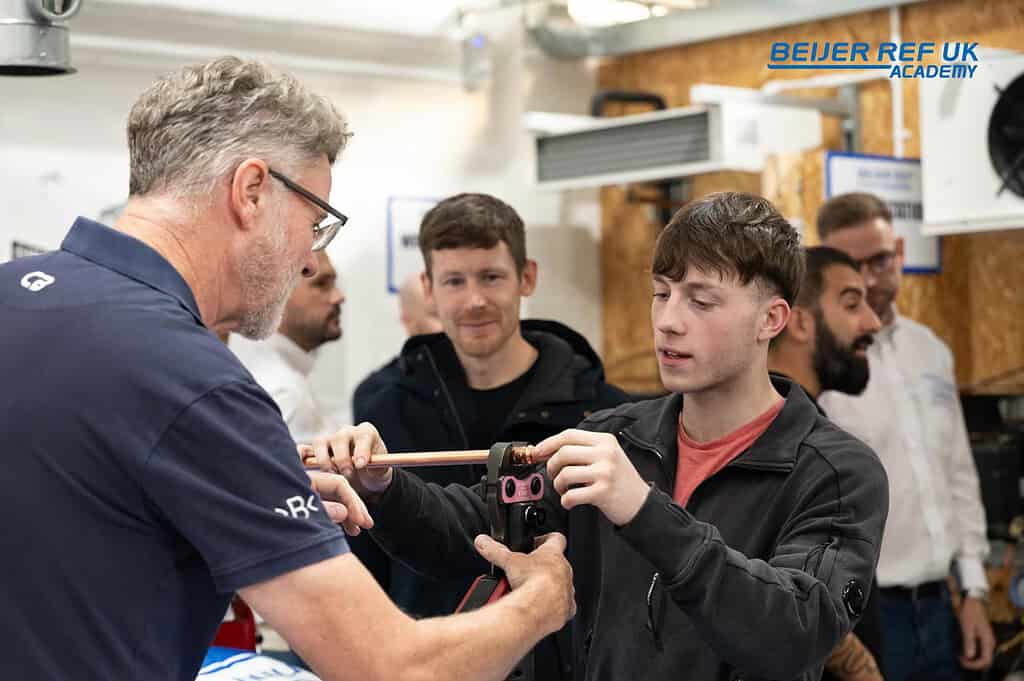 Young technician learning HVACR skills from expert at Wetherby Academy.