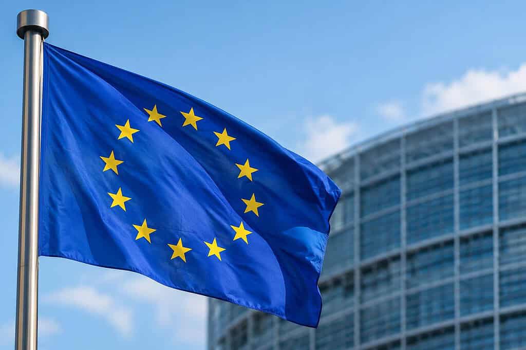 European Union flag flying outside a modern office building.
