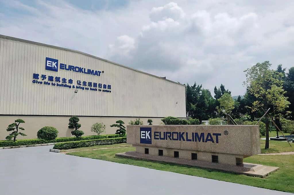 Euroklimat logo on industrial building with greenery and sky.