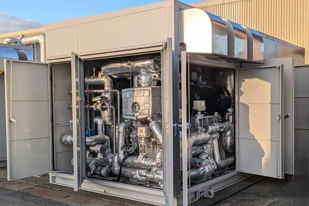 Industrial heat pump unit with insulated pipes and control panels.