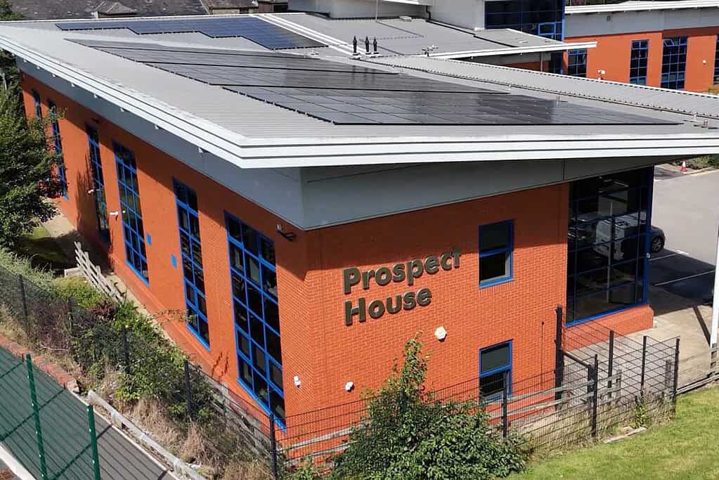 Prospect House building with solar panels on roof and blue window frames.